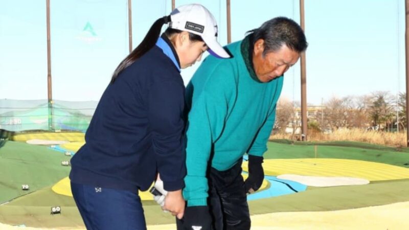 西郷真央選手がジャンボ尾崎さんにジュニアレッスン会で指導を受けているシーン