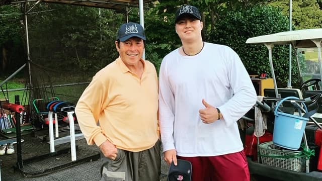 ジャンボ尾崎さんとがお孫さんの尾崎将哉さんと並んで笑顔で撮影しているところ。