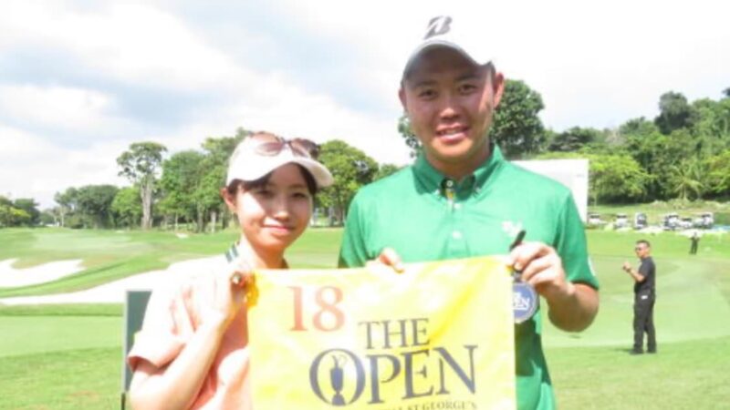 ゴルフ場で選手と妻が笑顔で記念撮影をしている様子