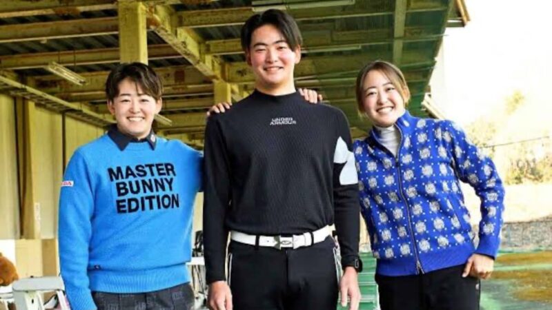 双子姉妹が弟をはさんでゴルフ練習場で記念撮影している様子