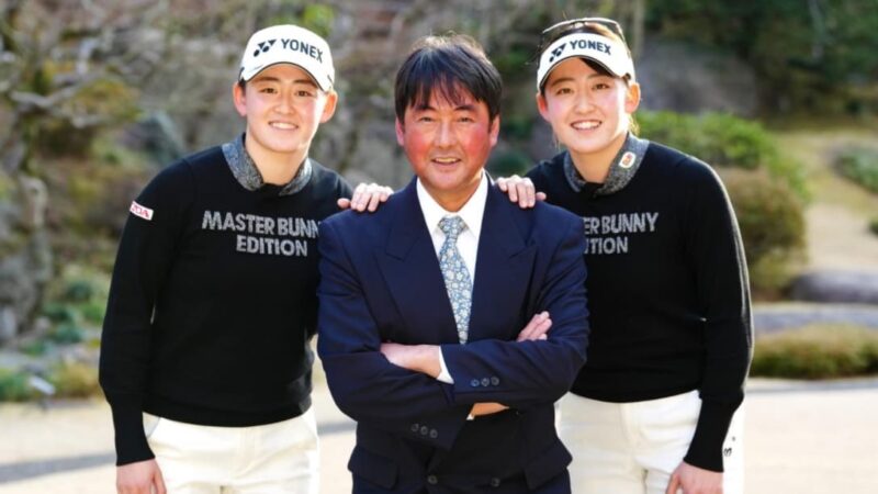 双子姉妹がコーチと記念撮影している様子